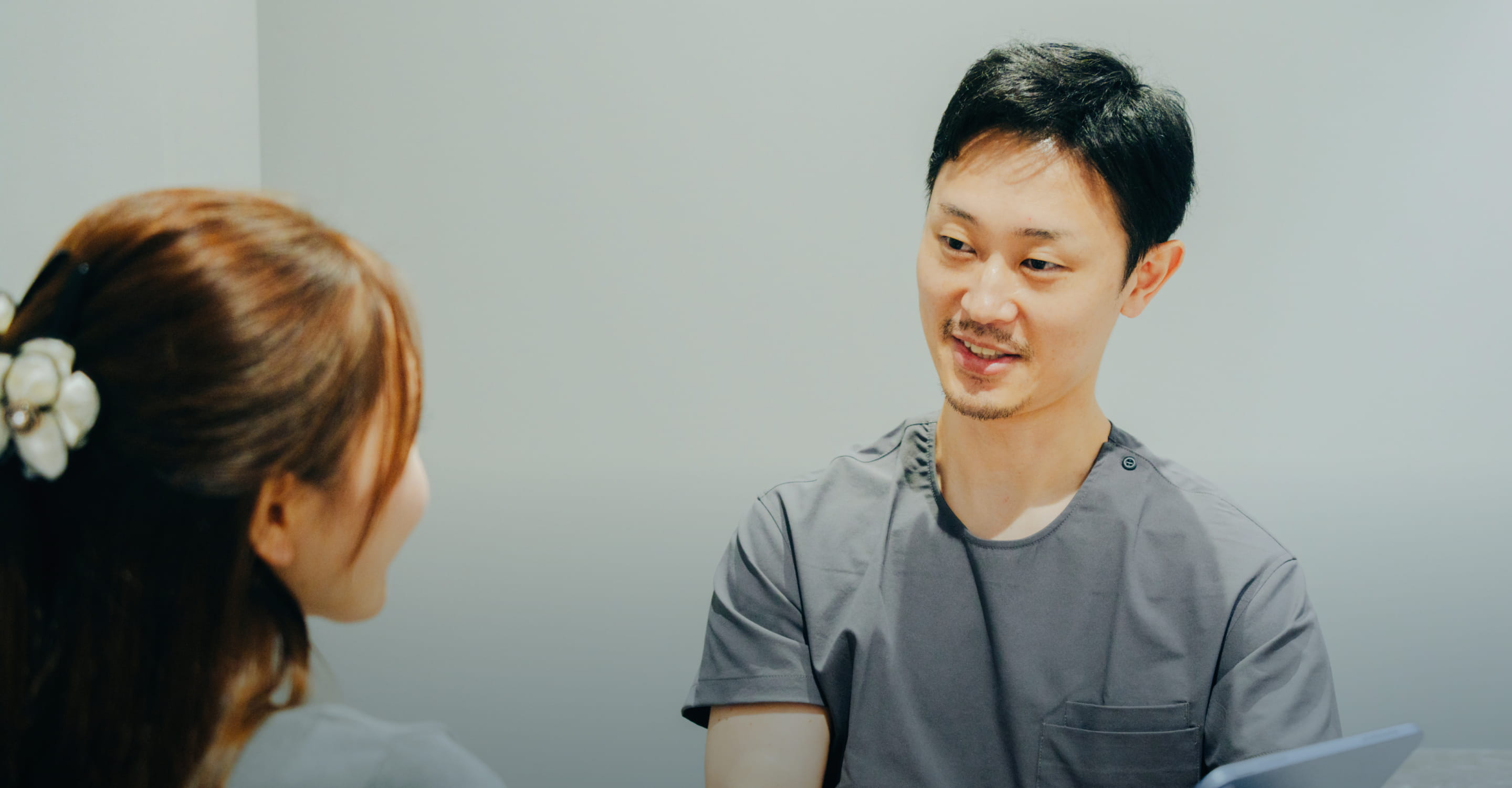 嶋﨑仁孝院長が患者に診察内容を説明しカウンセリングを行う様子
